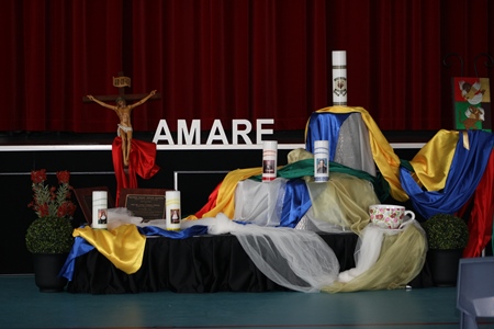 school religious display with crucifix, candles and coloured cloth arranged beneath AMARE values backdrop